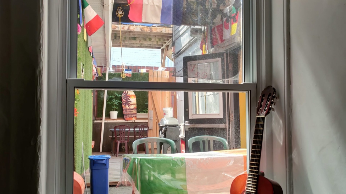 A from inside a hostel window in Quebec CIty, Canada, with a guitar, a water bottle and several country flags